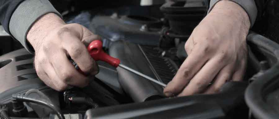 mechanic's hands working on a motor using a device