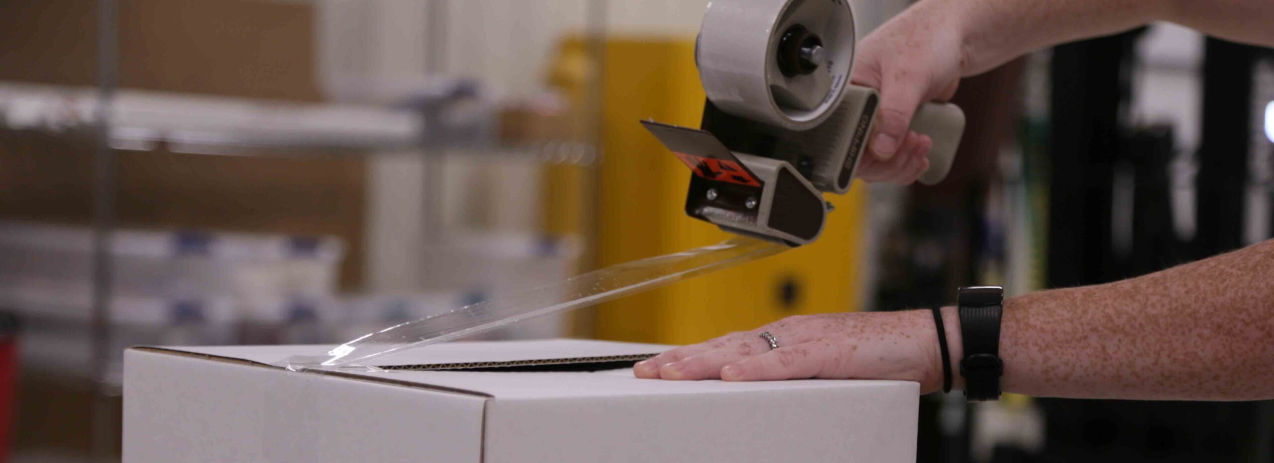 employee taping up a box for shipment